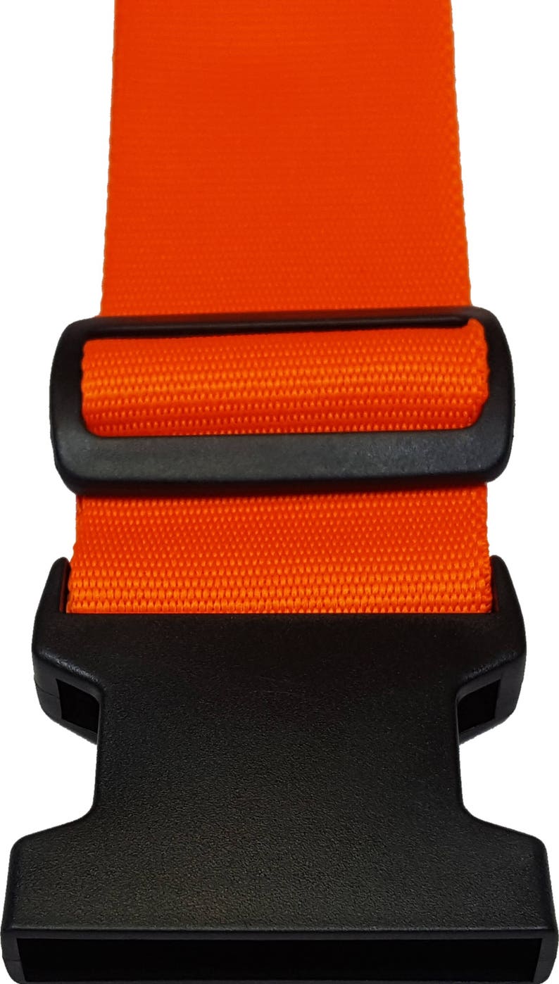 The image features a orange -coloured strap with a black plastic buckle, typically used for securing items like luggage.