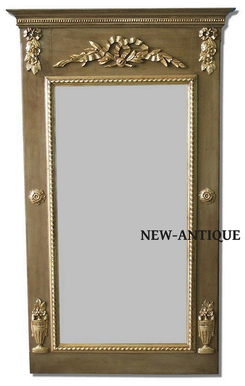 May include: An antique-style mirror with a rectangular shape, featuring a gold-coloured frame and decorative elements. The frame is a muted olive green with gold trim and ornate floral and ribbon details. The text "NEW-ANTIQUE" is visible on the mirror.