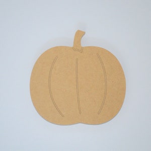 May include: A plain, unfinished wooden pumpkin cutout. The pumpkin is a simple shape with a stem and two lines to represent the pumpkin's ridges.