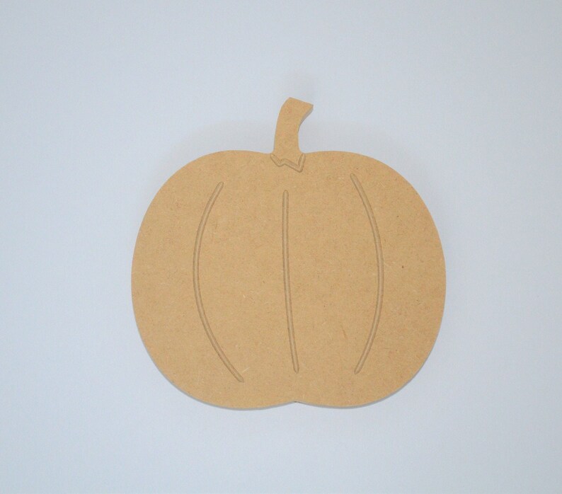 May include: A plain, unfinished wooden pumpkin cutout. The pumpkin is a simple shape with a stem and two lines to represent the pumpkin's ridges.
