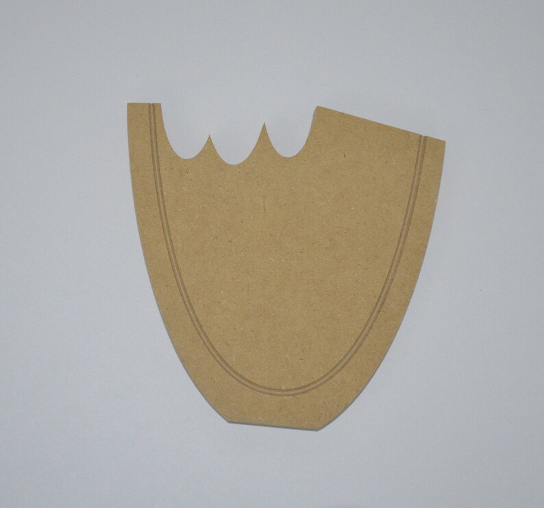May include: A brown wooden cutout in the shape of a vase with a scalloped top edge. The cutout has a double line around the edge.