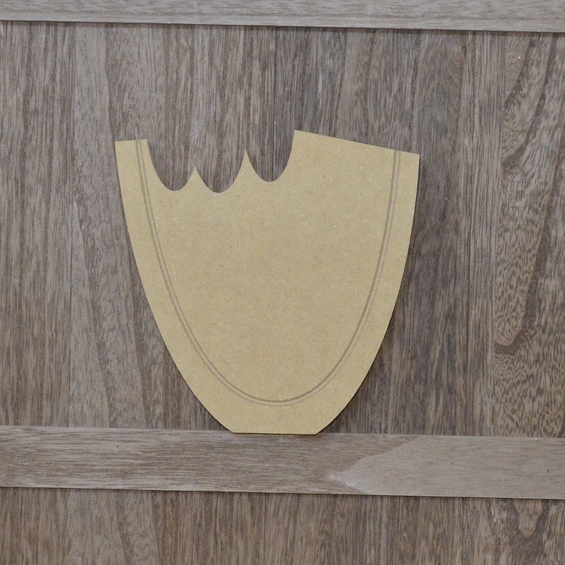 May include: A brown paper pattern for a craft project. The pattern is shaped like a curved, asymmetrical shape with a rounded bottom and a pointed top.