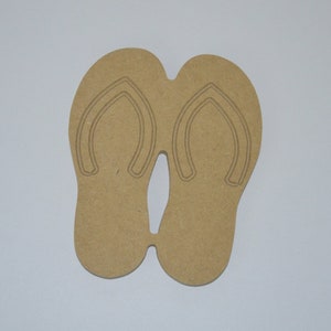May include: A pair of brown wooden flip-flop cutouts. The flip-flops are connected at the toe and heel.
