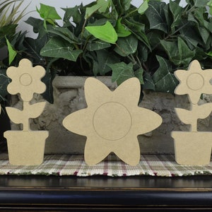 May include: Five unfinished wooden flower shapes, two with stems and pots, ready for painting and decorating.  These wooden flower shapes are perfect for crafting and home decor.