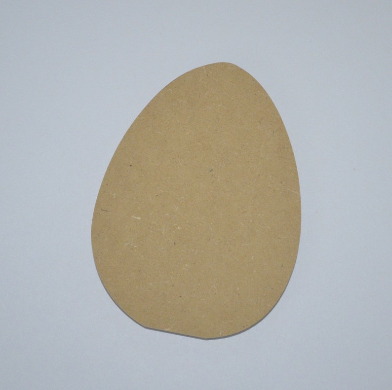May include: A light brown, oval-shaped piece of cardboard. It is blank and could be used for crafts or decorations.