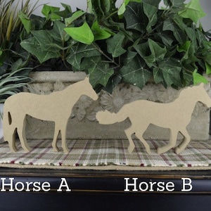 May include: Two wooden horse silhouettes, one standing and one running, on a plaid surface. The standing horse is labeled "Horse A" and the running horse is labeled "Horse B".