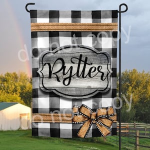 May include: Black and white buffalo check garden flag with a brown burlap bow and a wooden sign that says "Rytter".