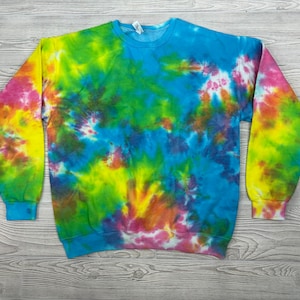 Könnte beinhalten: Ein tie-dye Sweatshirt in den Farben Blau, Grün, Gelb, Rosa und Orange. Das Sweatshirt hat einen Rundhalsausschnitt und lange Ärmel.