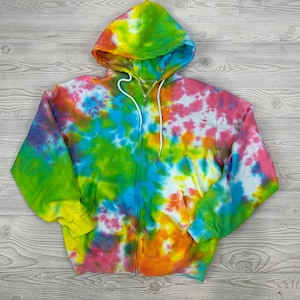 Könnte beinhalten: Ein tie-dye Kapuzenpullover mit Reißverschluss in einem leuchtenden Regenbogenmuster. Der Hoodie hat eine Kapuze und einen Reißverschluss vorne.