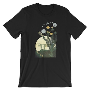 May include: Black t-shirt with a graphic print of two fairies standing in front of a moon and dandelions with a butterfly flying above them.