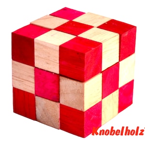 May include: A wooden cube puzzle with red and natural wood coloured squares. The cube is made of 27 smaller cubes that can be moved and rearranged.