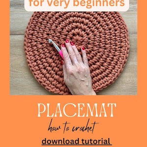 May include: A close-up of a crocheted orange placemat with a hand holding a crochet hook. The text "for very beginners" is at the top of the image. The text "PLACEMAT" is in large letters at the bottom of the image. The text "how to crochet" is below the word "PLACEMAT". The text "download tutorial" is below the text "how to crochet". The text "download pattern" is below the text "download tutorial".