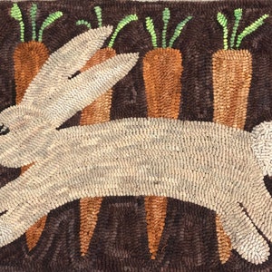 May include: A white rabbit hops through a field of brown carrots with green tops. The rabbit is made of woven fabric and the carrots are made of a similar material. The background is a dark brown color.