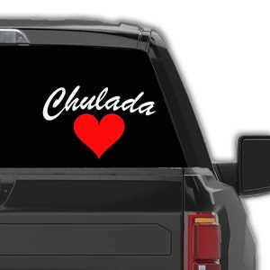 May include: A black truck with a white decal that says "Chulada" with a red heart.