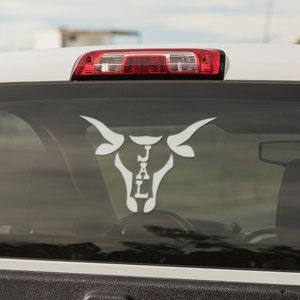 May include: White truck with a white bull head decal on the back window. The decal has the letters "J A L" inside the bull's head.