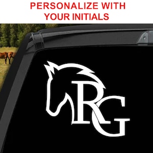 May include: White decal featuring a horse head silhouette with the initials "RG" on a black background. The text "PERSONALIZE WITH YOUR INITIALS" is displayed in red at the top. The image is on a car window with a blurred background of horses.