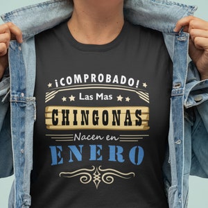 May include: Black t-shirt with a vintage-style graphic that says "¡COMPROBADO! Las Mas CHINGONAS Nacen en ENERO" in Spanish.
