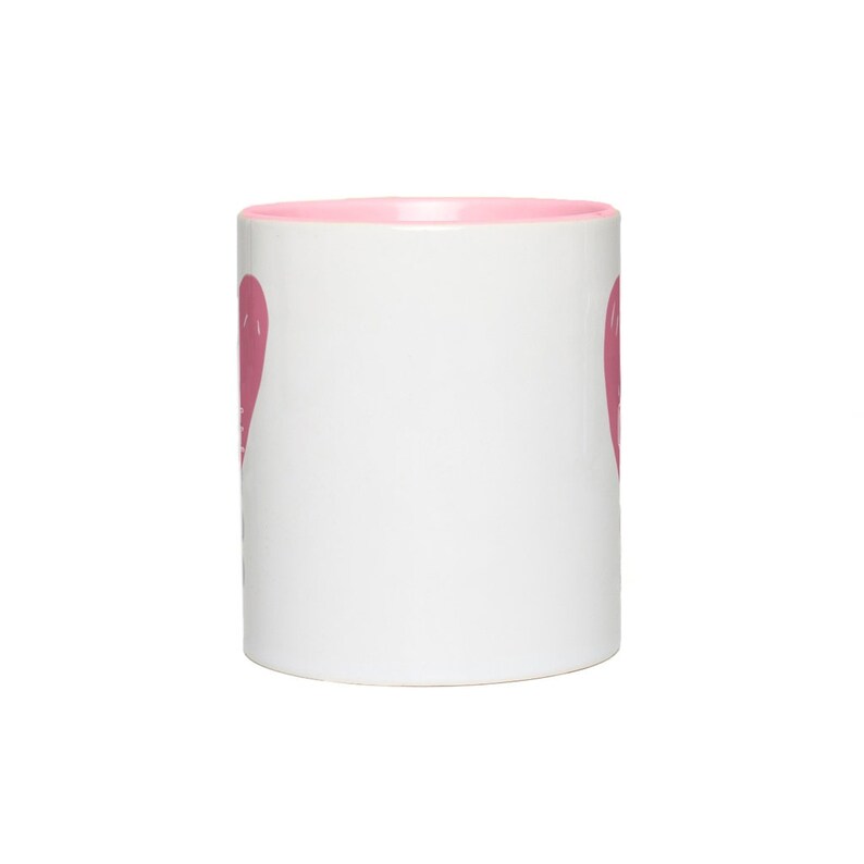 May include: A white ceramic mug with a pink rim and a pink heart design on each side.
