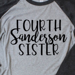Puede incluir: Una camiseta de manga raglan gris y negra con el texto "FOURTH Sanderson SISTER" impreso en negro.
