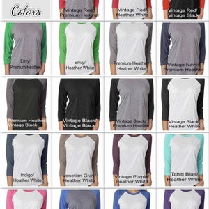 May include: A grid of 12 different color combinations for a raglan shirt. The shirt is a baseball style with a contrasting color on the sleeves. The colors include vintage red, envy, premium heather, vintage black, indigo, venetian gray, vintage purple, tahiti blue, vintage pink, vintage royal, and purple rush.