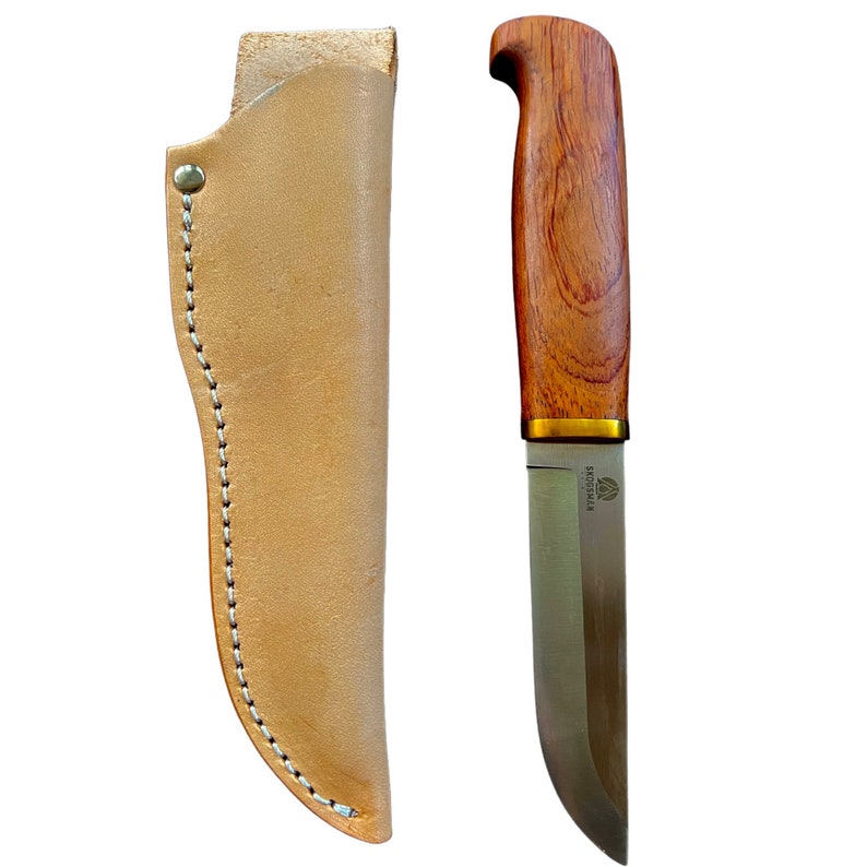 May include: A hunting knife with a wooden handle and a stainless steel blade, accompanied by a tan leather sheath. The knife features a curved blade and a brass bolster. The sheath is stitched with white thread.