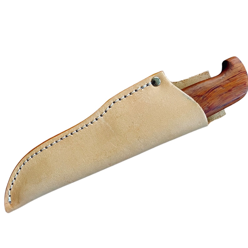 May include: A handcrafted knife with a wooden handle and a leather sheath. The knife handle is a rich brown color, and the sheath is a light tan color. The sheath is stitched with white thread and has a metal rivet.