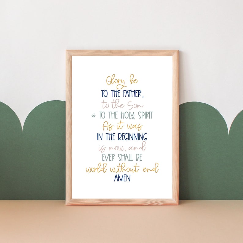 May include: A framed print with a white background and a navy blue and gold text that reads "Glory be to the Father, to the Son, & to the Holy Spirit. As it was in the beginning is now, and ever shall be world without end. Amen."