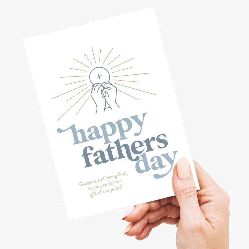 A hand holds a white greeting card with "happy fathers day" in blue and gray, and a communion host and hands graphic.