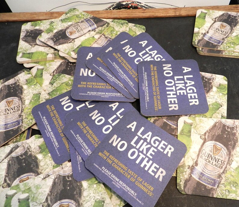 May include: A stack of blue and white square coasters with the text "A Lager Like No Other" and the words "The refreshing taste of lager with the character of Guinness."  Please drink responsibly.