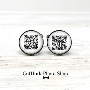 May include: A pair of silver cufflinks with a black and white QR code design.