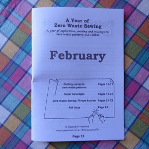 May include: A Year of Zero Waste Sewing booklet with a February cover page. The booklet includes information on putting curves in zero waste patterns, super selvedges, zero waste stories, and Ask Lizzy. The booklet is on a checkered tablecloth.