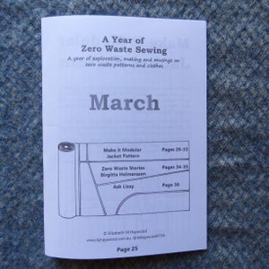 May include: A white booklet with the title "A Year of Zero Waste Sewing" and the month "March" printed on the cover. The booklet includes information about making a modular jacket pattern, zero waste stories, and an interview with Birgitta Helmersson. The booklet is on a blue textured surface.