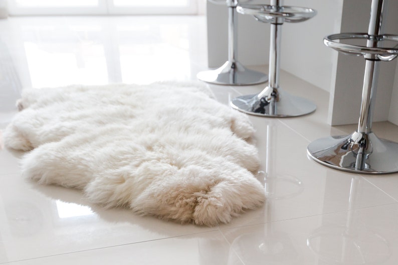 Cream white sheepskin rug laying flat on the dining room floor