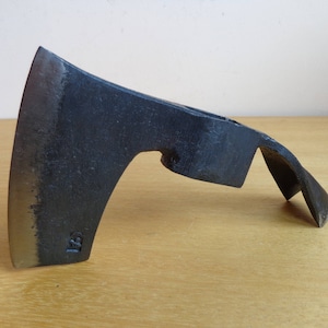 May include: A black metal axe with a curved blade and a handle. The axe has a small hole in the handle for hanging.