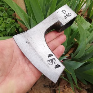 Puede incluir: Un hacha de plata con mango de madera. La cabeza del hacha tiene el texto "D 450" y "VA" estampado.