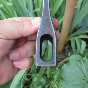 Puede incluir: Primer plano del ojo de una cabeza de hacha. El ojo es un agujero redondo en el centro de la cabeza del hacha, que se utiliza para sujetar el mango.
