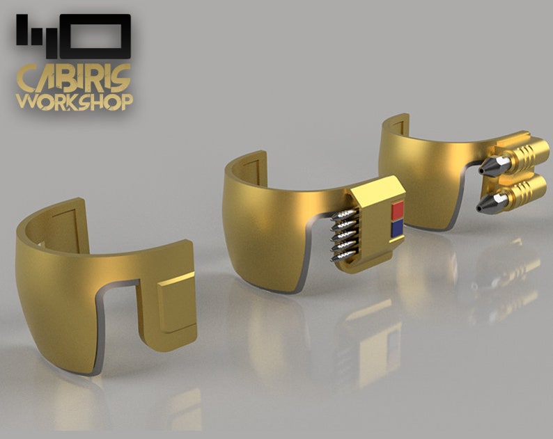 May include: Three gold-coloured pieces of a futuristic helmet with a red and blue detail on one piece and a series of small silver cylinders on another piece.