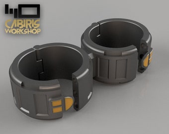 May include: Two black metal rings with a hinge and a yellow accent. The rings are designed to be joined together.