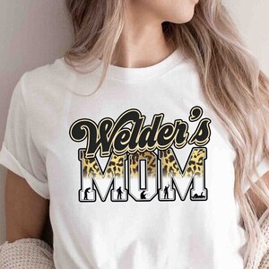 May include: White t-shirt with a black and gold graphic that says "Welder's Mom" with a leopard print design.