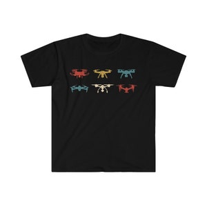 May include: Black t-shirt featuring six drone illustrations in red, gold, teal, blue, white, and red. The drones are arranged in two rows of three. The shirt is made of a soft, comfortable material.