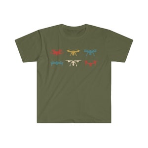 May include: Olive green t-shirt featuring a retro design of six drones in various colors: red, yellow, blue, teal, white, and red. The drones are arranged in two rows of three. A casual, short-sleeved tee.