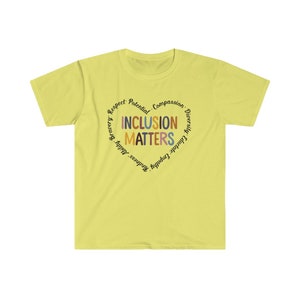 May include: A yellow t-shirt with a circle design that says "Inclusion Matters" in a heart shape. The words around the heart are "Respect, Potential, Compassion, Diversity, Educate, Empathy, Kindness, Bravery,  Adult,  and  Others."