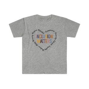 May include: Gray t-shirt with a circle design that says "Inclusion Matters" in colorful letters. The circle is surrounded by words like "Respect", "Potential", "Compassion", "Diversity", "Equality", "Empathy", "Kindness", "Health", "Bravery", and "Mindfulness".