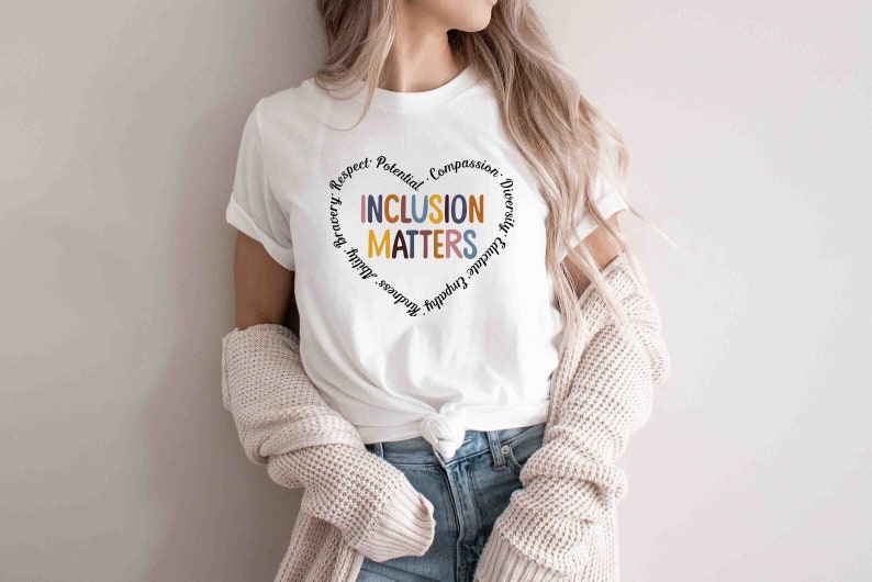 May include: White t-shirt with a heart-shaped design that says "Inclusion Matters" surrounded by the words "Respect, Potential, Compassion, Diversity, Gratitude, Empathy, Kindness, Bravery,  Adult"