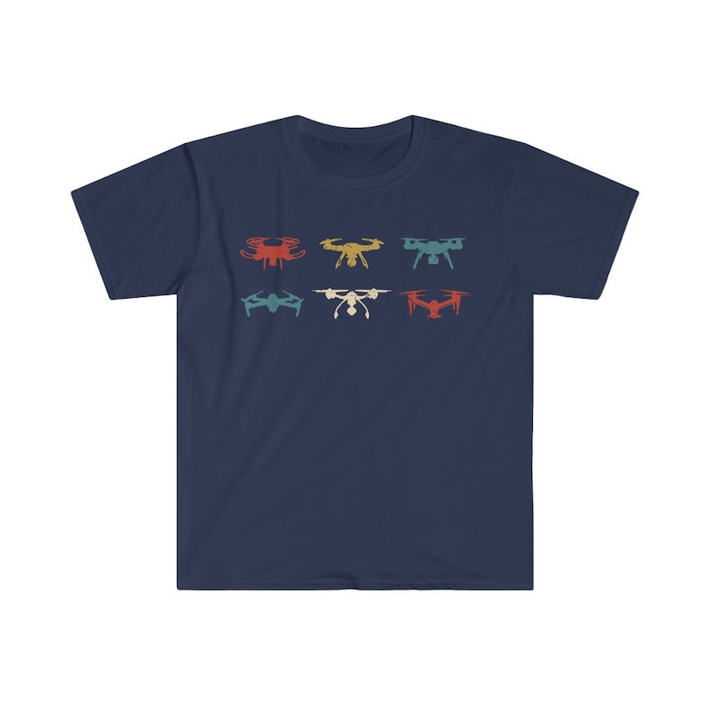 May include: Navy blue t-shirt featuring a retro design of six different drones in various colors. The drones are arranged in two rows of three, with colors including red, yellow, and teal. The shirt is made of a soft material.