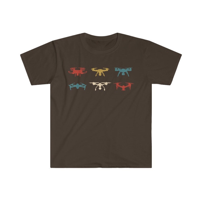 May include: A brown t-shirt featuring a retro design of six drones in various colors: red, yellow, teal, blue, white, and red. The drones are arranged in two rows of three. The shirt is made of a soft material.
