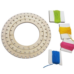Puede incluir: Un anillo de madera con tres círculos concéntricos, cada uno con agujeros espaciados uniformemente. Los círculos están etiquetados con números del 1 al 30. Se incluyen cuatro carretes de hilo: verde, amarillo, rosa y azul.