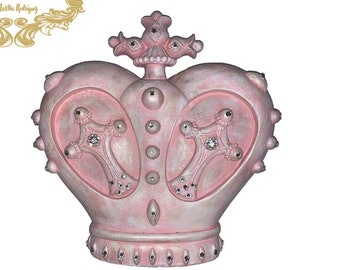 May include: A pink heart-shaped crown with a cross on top and rhinestones. The crown is decorated with silver and white accents.