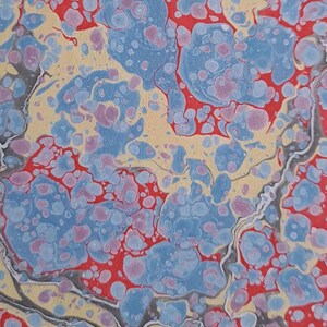 May include: Abstract marbled paper design. The pattern features light blue, red, and purple shapes on a yellow background, with dark grey veins. The overall effect is a unique, artistic texture. The measurements are in centimetres.