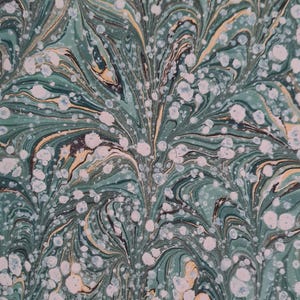 May include: A close-up of a marbled pattern in shades of teal, dark green, and gold. The design features swirling lines and white, circular accents. The overall effect is similar to decorative paper or fabric.